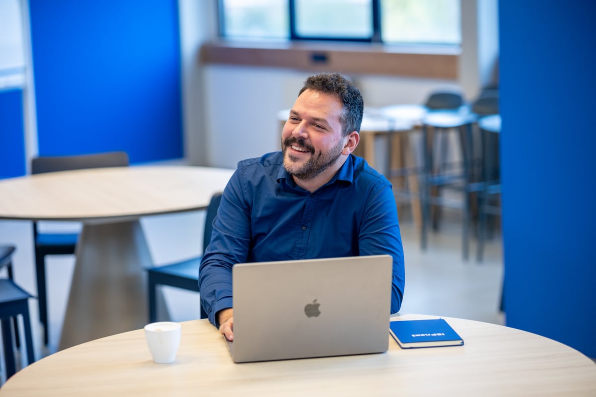 IT Manager van ISPnext werkt geconcentreerd aan zijn laptop op kantoor