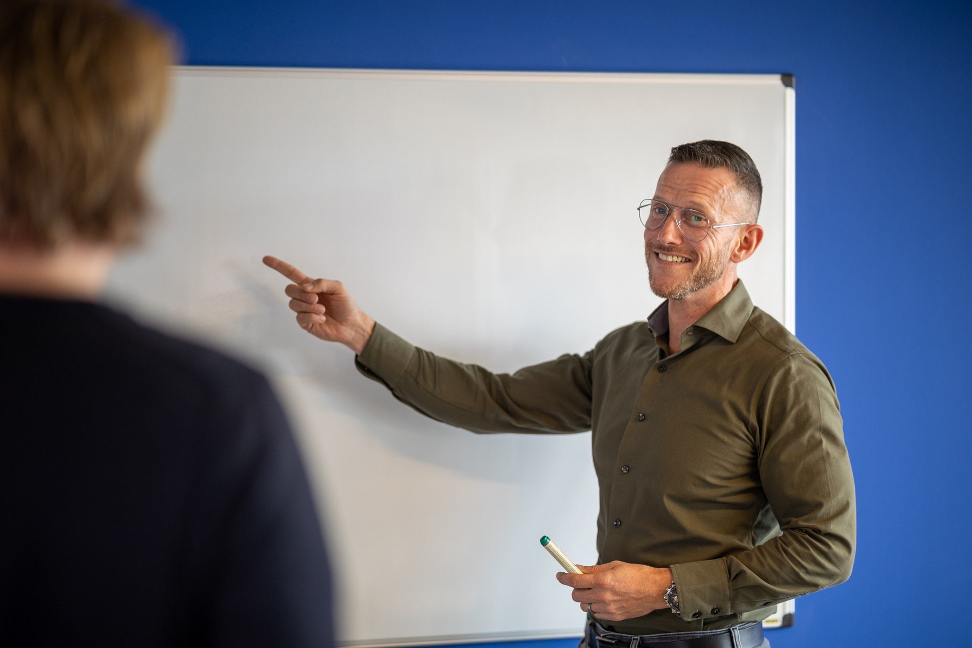 ISPnext-specialist wijst iets aan op het whiteboard tijdens een gesprek over AP Automation voor SyteLine